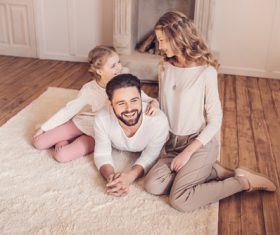Happy family sitting on the carpet Stock Photo