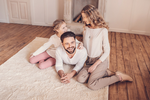Happy family sitting on the carpet Stock Photo