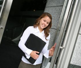Holding black leather bag girl opening door Stock Photo
