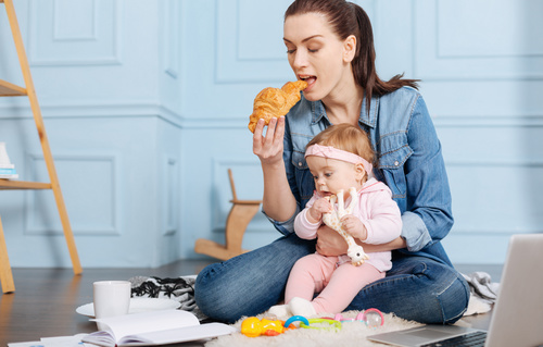 Housewife holding a child to eat Stock Photo