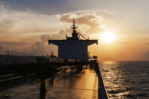 Large freighter driving in the sea in the sunset Stock Photo