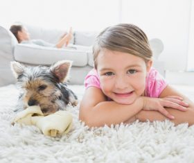 Little girl and pet dog lying on the carpet Stock Photo