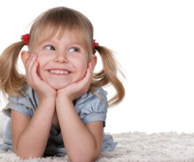 Little girl lying on the carpet Stock Photo