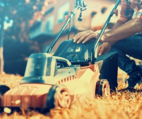 Man cleans the hand-push lawn mower Stock Photo 04