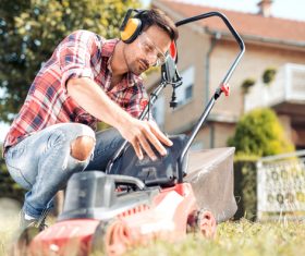 Man cleans the hand-push lawn mower Stock Photo 05