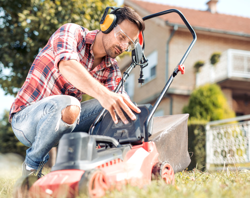 Man cleans the hand-push lawn mower Stock Photo 05