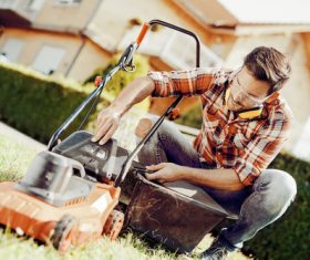 Man cleans the hand-push lawn mower Stock Photo 06