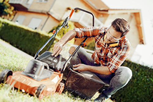 Man cleans the hand-push lawn mower Stock Photo 06