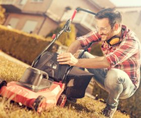 Man cleans the hand-push lawn mower Stock Photo 07