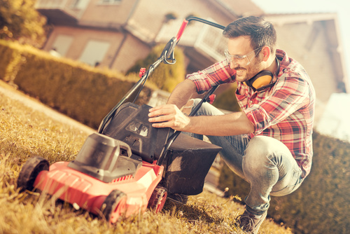 Man cleans the hand-push lawn mower Stock Photo 07