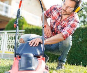 Man cleans the hand-push lawn mower Stock Photo 08