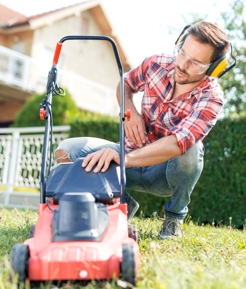 Man cleans the hand-push lawn mower Stock Photo 08