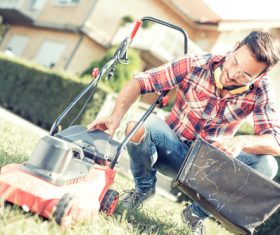 Man cleans the hand-push lawn mower Stock Photo 09