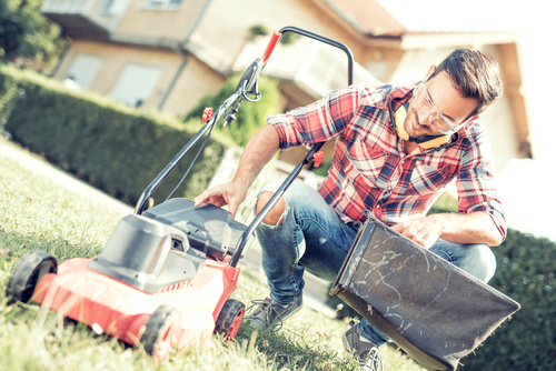 Man cleans the hand-push lawn mower Stock Photo 09
