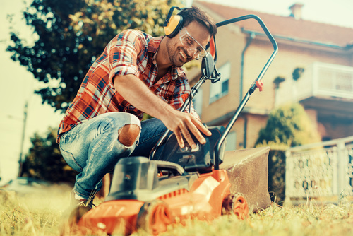 Man cleans the hand-push lawn mower Stock Photo 10