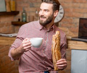 Man drinking coffee and eating bread Stock Photo