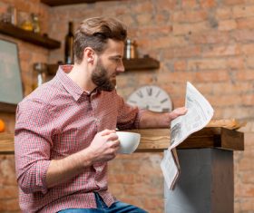 Man drinking coffee and reading newspaper Stock Photo 01