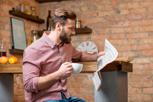 Man drinking coffee and reading newspaper Stock Photo 01