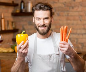 Man holding colorful peppers and carrots Stock Photo