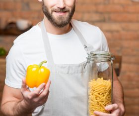 Man holding colorful peppers and spaghetti Stock Photo