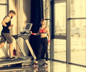 Man on treadmill and woman standing next to Stock Photo