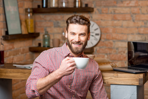 Man sitting at home drinking coffee Stock Photo