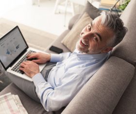 Man sitting on the couch surfing the internet Stock Photo