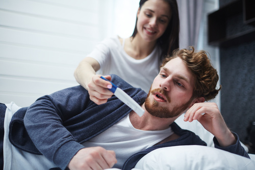 Married couple looking at positive pregnancy test Stock Photo 01