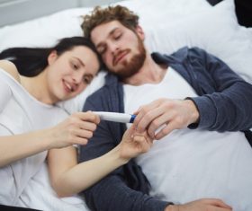 Married couple looking at positive pregnancy test Stock Photo 02