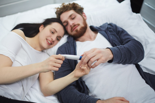 Married couple looking at positive pregnancy test Stock Photo 02