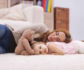 Mother and daughter lying on the carpet Stock Photo