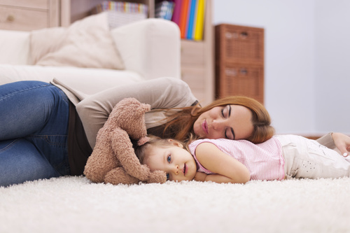 Mother and daughter lying on the carpet Stock Photo