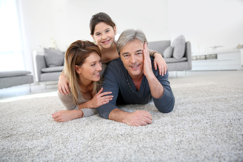 Parents and children lying on the carpet Stock Photo