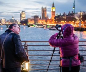 People photographing the city at night on the bridge Stock Photo