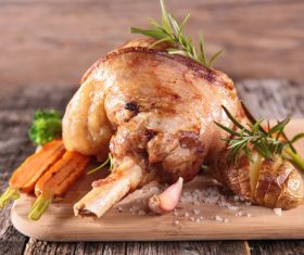 Roasted leg of lamb and carrot on cutting board Stock Photo