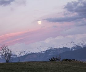 Round sun above snowy mountain Stock Photo