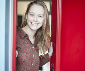 Smiling girl opening the door Stock Photo