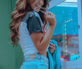 Smiling pretty girl in front of doll machine Stock Photo