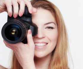 Smiling woman photographing with camera Stock Photo