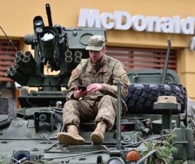Soldiers in armored cars look at mobile phones Stock Photo