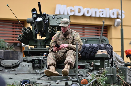 Soldiers in armored cars look at mobile phones Stock Photo