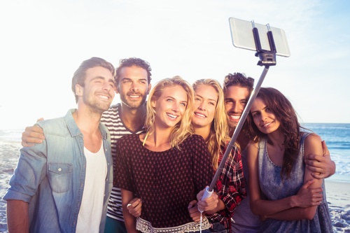Standing on the beach young friends selfie Stock Photo