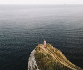 Standing on the hillside watching the sea Stock Photo