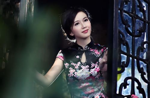 Stock Photo Asian cheongsam girl standing in front of the window