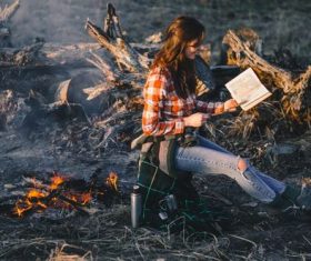 Stock Photo Girl looking at the map by the campfire