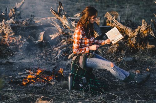 Stock Photo Girl looking at the map by the campfire