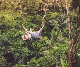 Stock Photo Girl playing swing in the forest