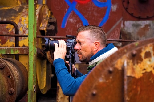 Stock Photo Male photographer shooting abandoned factory building