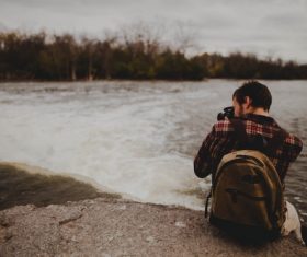 Stock Photo Man taking photos by the lake