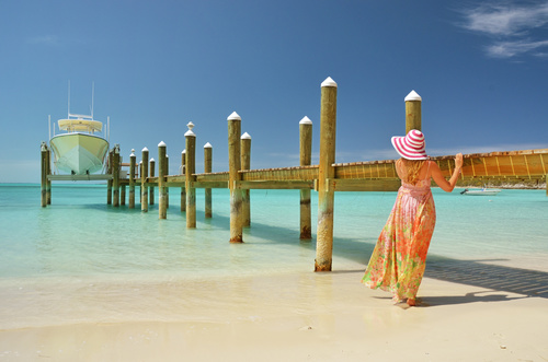 Stock Photo Woman standing next to the pier looking at the yacht